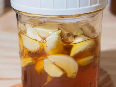mason jar of honey and garlic with a white plastic lid
