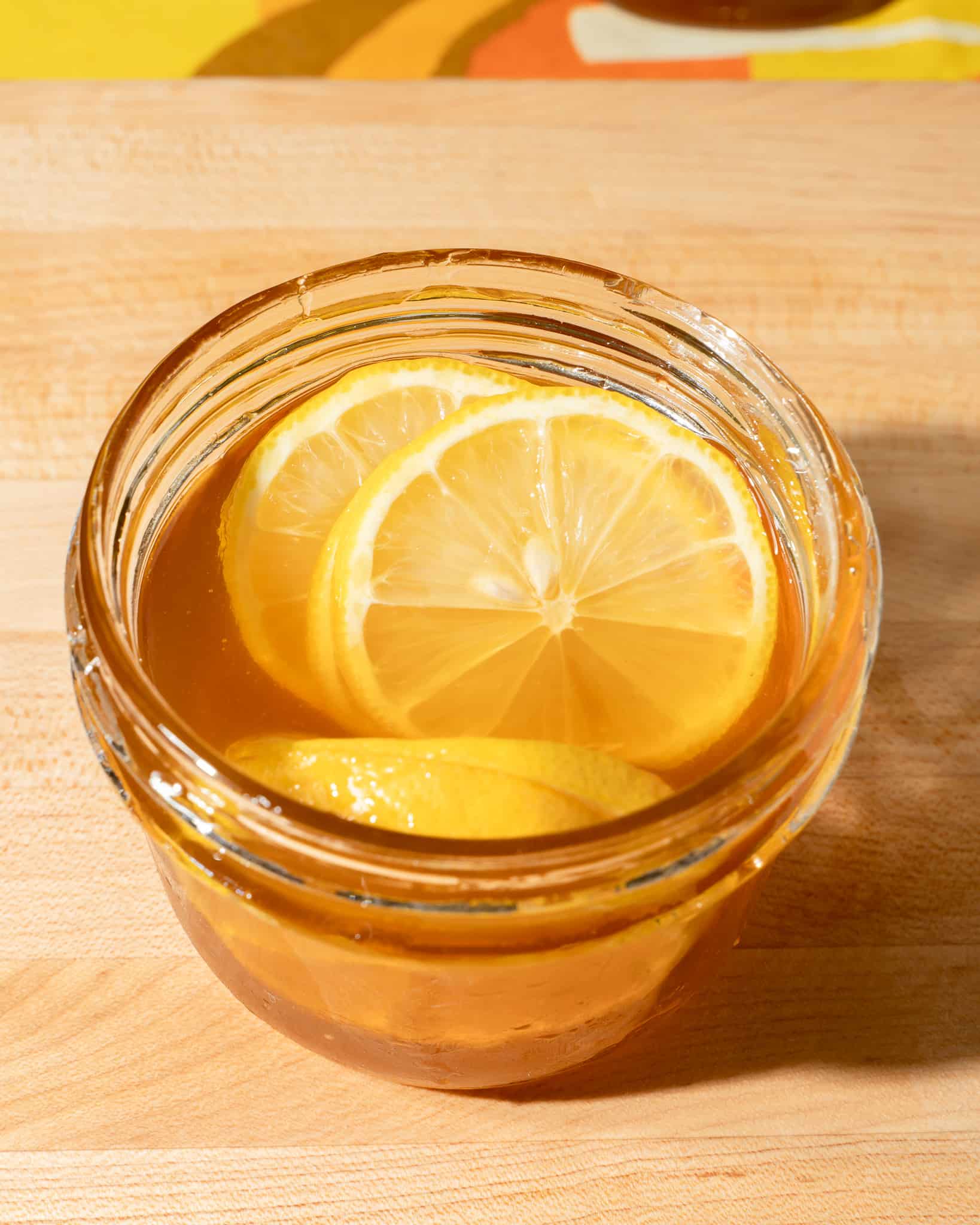 lemon and ginger slices in a mason jar filled with honey