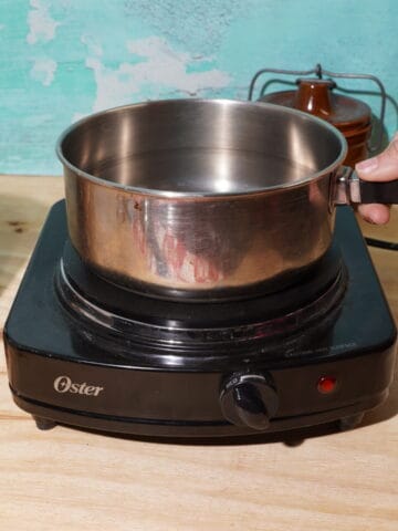 person holding a pot of broth
