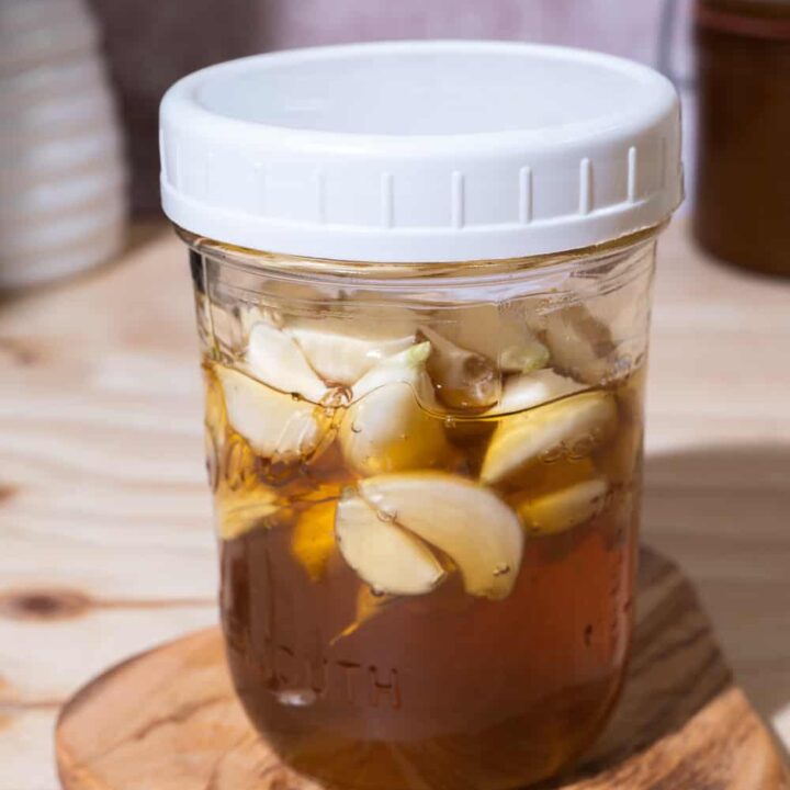 mason jar with white screw lid with fermented garlic honey