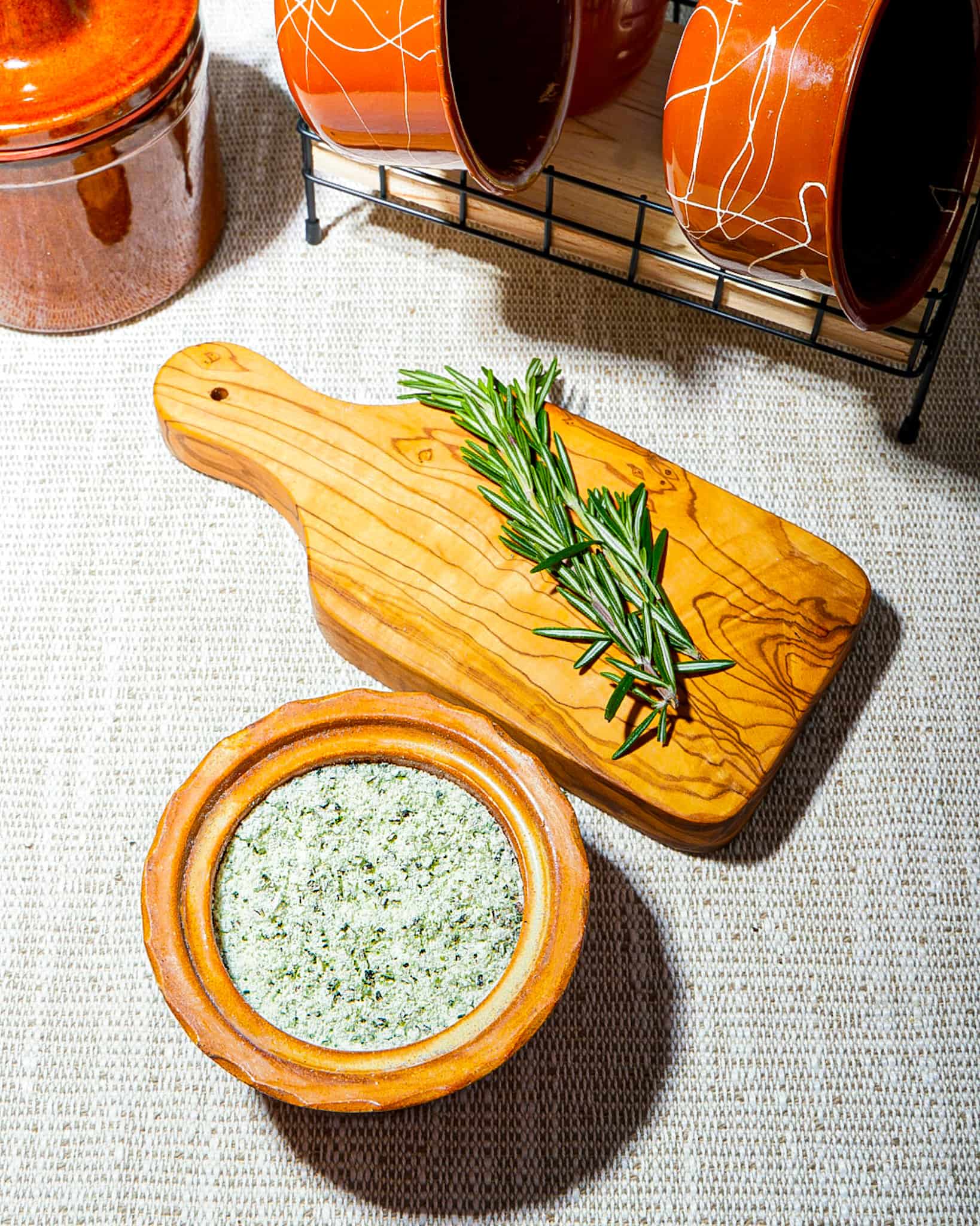 jar of green rosemary salt with two sprigs