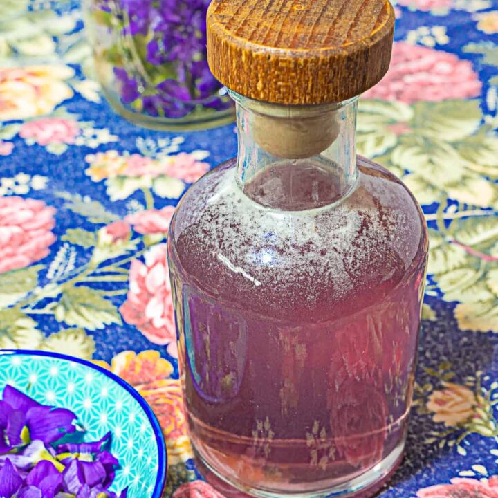 glass bottle with wooden cap with purple simple syrup