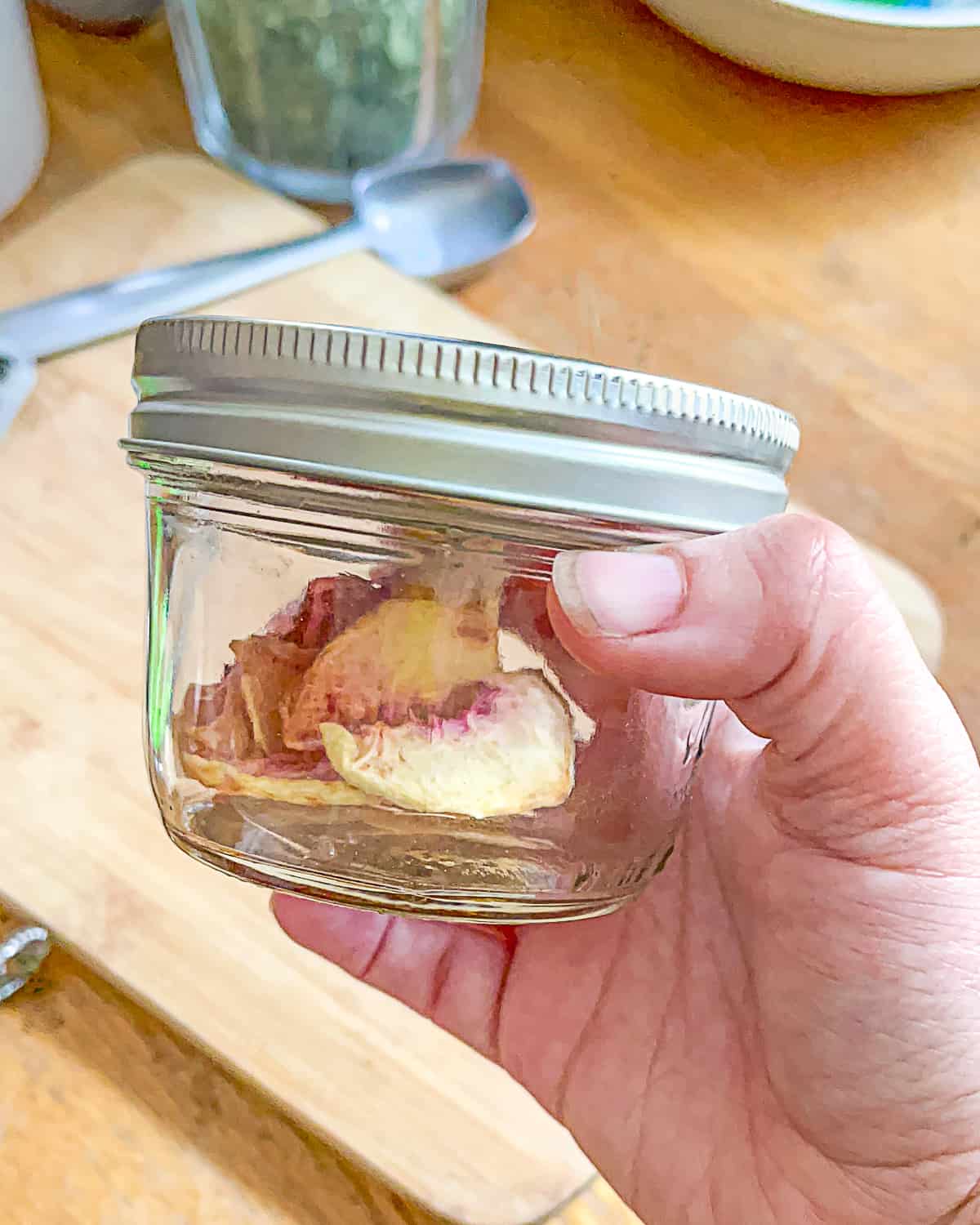 person holding jar of dried peaches