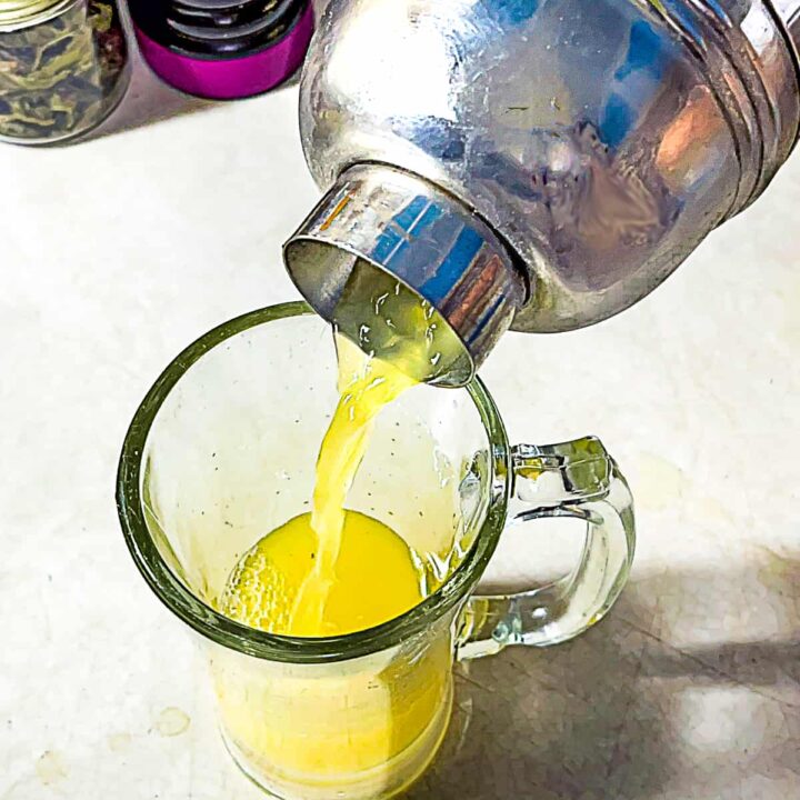 person pouring version of starbucks peach green tea lemonade recipe into tall glass