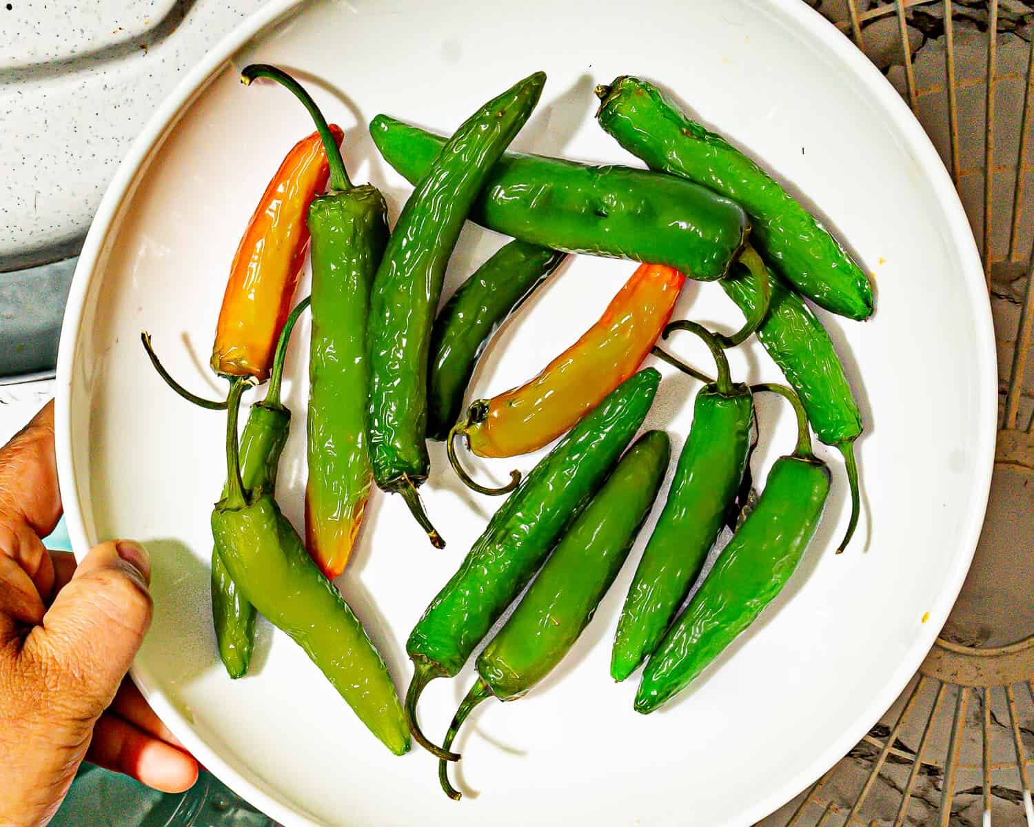 person holding plate with fresh serrano peppers