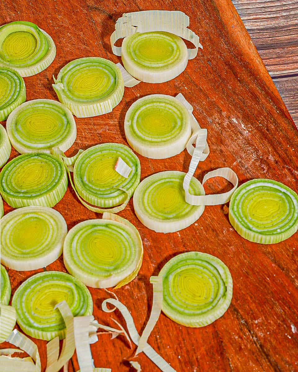 close up of sliced dried leek rings on a red-brown wooden board