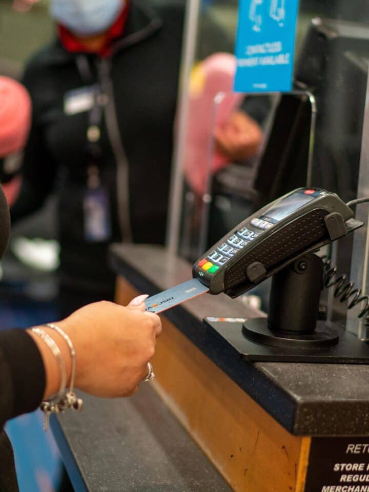 A person checking out at a desk with a credit card.
