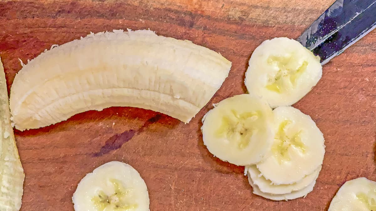 sliced banana on a wooden cutting board