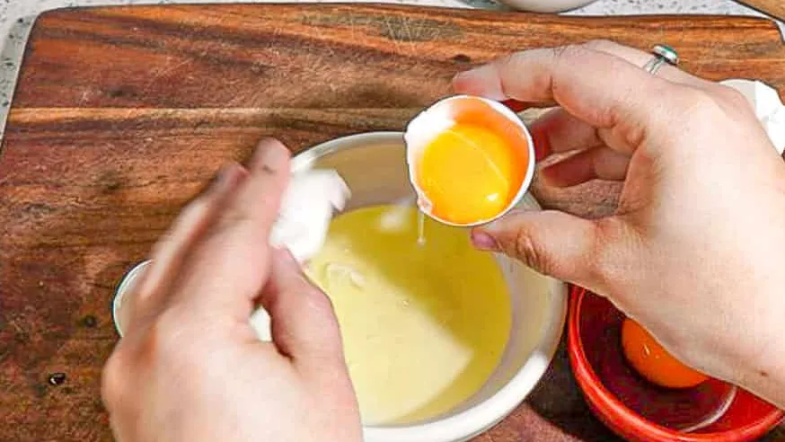 person separating egg white and yolk